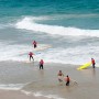 First days of surf course are run in shallow water. Students learn to catch “white waves”